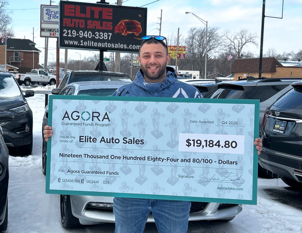 Agora Dealer holding a big check
